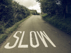 Vintage looking Slow sign Vintage looking Slow sign painted on tarmac on a british road near a school