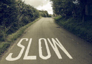 Vintage looking Slow sign painted on tarmac on a british road near a school